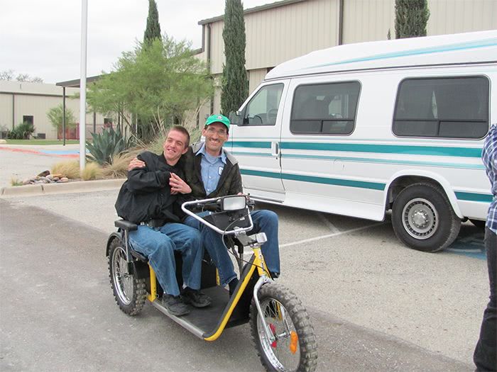 Harrold and a young man smiling on the Yellow Modified 3-Wheeler.