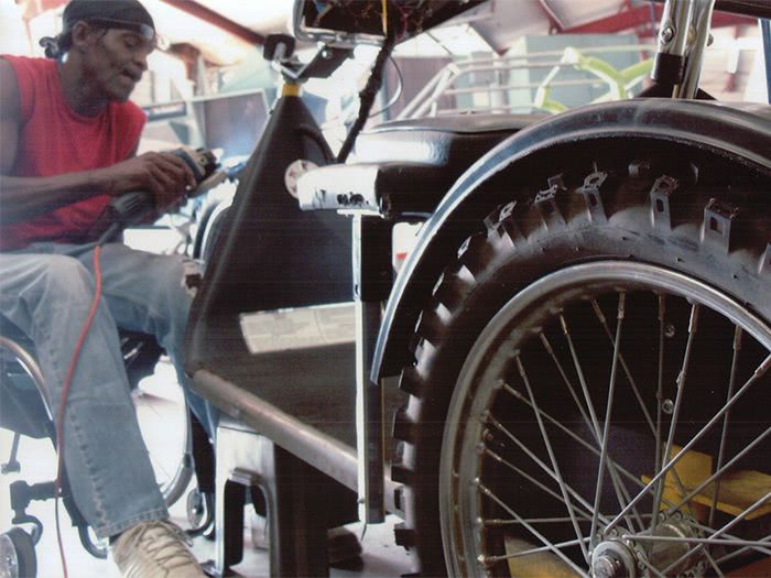 Tommie works on widening the front fork to accommodate the larger wheel.