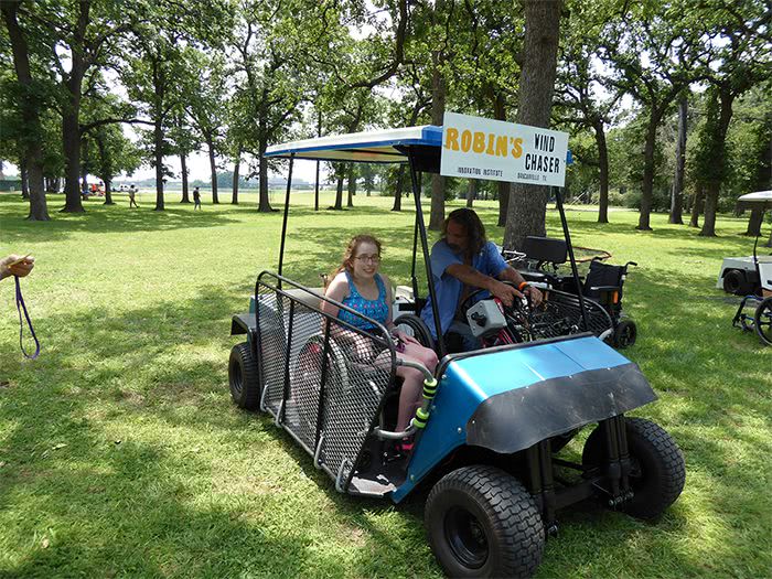 Ed gives a young woman a ride on the Blue Hybrid Kart.