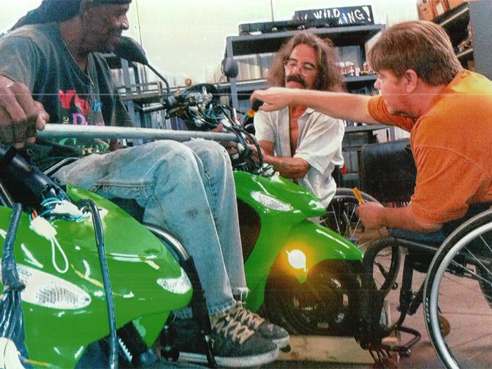 Tommie, Ed, and Tony install a crossbar on the Twin Scooters.